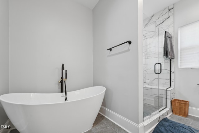 bathroom with a freestanding bath, marble finish floor, baseboards, and a marble finish shower