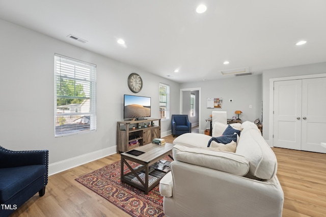 living room with light wood-type flooring, baseboards, visible vents, and recessed lighting