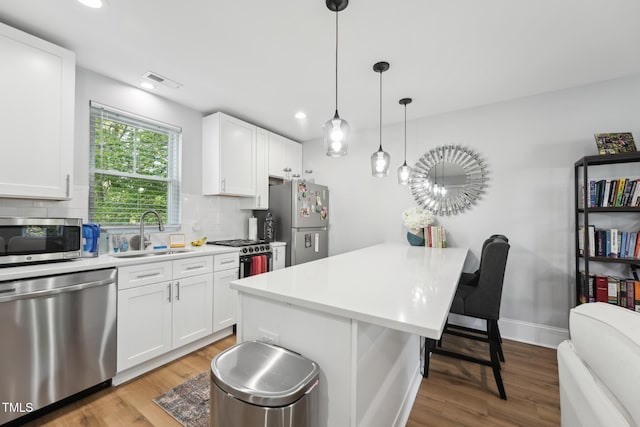 kitchen featuring backsplash, visible vents, appliances with stainless steel finishes, and a sink