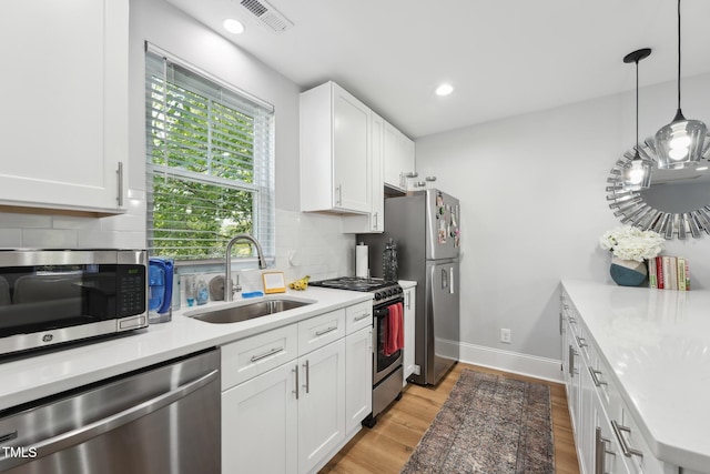 kitchen featuring decorative backsplash, a sink, white cabinetry, and appliances with stainless steel finishes