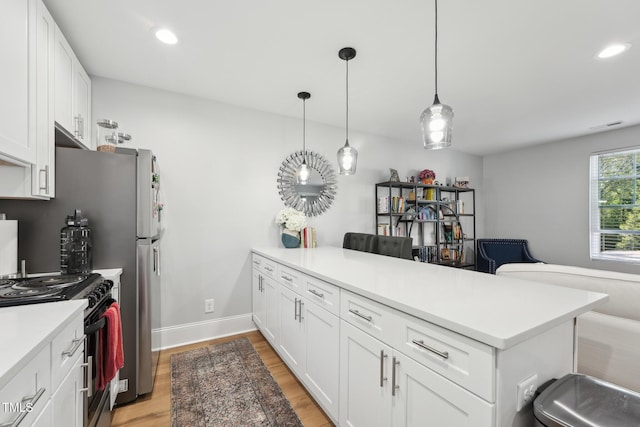 kitchen with white cabinets, a peninsula, light wood-style floors, gas range oven, and light countertops