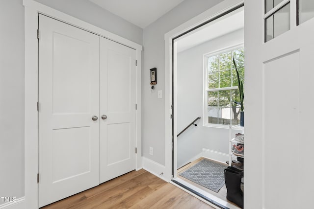 foyer featuring light wood-style floors and baseboards