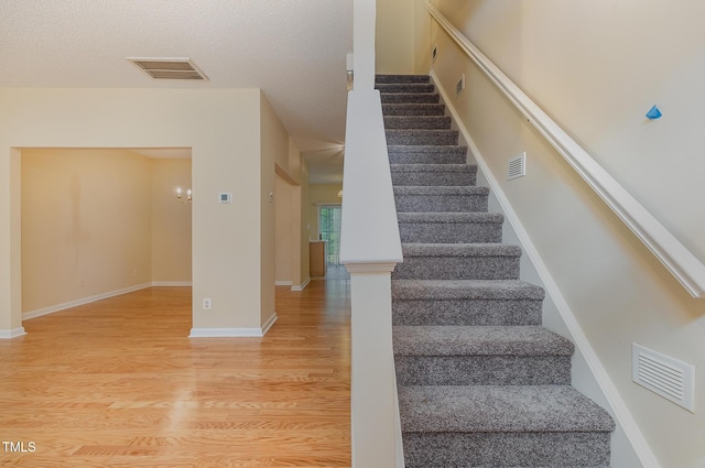 1031 Lake Moraine Pl, Raleigh, NC 27607 - staircase featuring wood finished floors, baseboards, and a textured ceiling