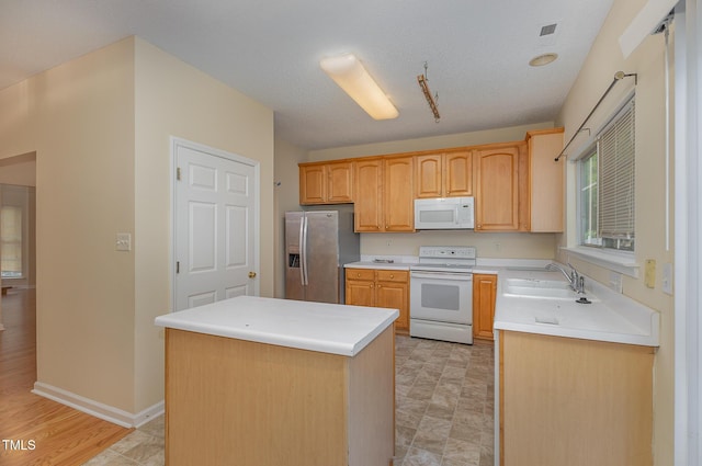 1031 Lake Moraine Pl, Raleigh, NC 27607 - kitchen with white appliances, a sink, a center island, light countertops, and baseboards