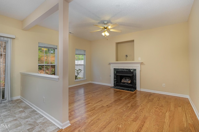1031 Lake Moraine Pl, Raleigh, NC 27607 - unfurnished living room with a fireplace, a ceiling fan, light wood-style flooring, and baseboards