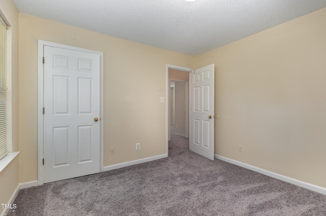 1031 Lake Moraine Pl, Raleigh, NC 27607 - unfurnished bedroom featuring carpet flooring, baseboards, and a textured ceiling