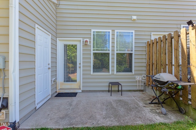 entrance to property with fence and a patio area