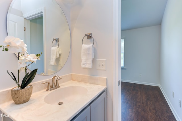 bathroom with vanity, baseboards, and wood finished floors