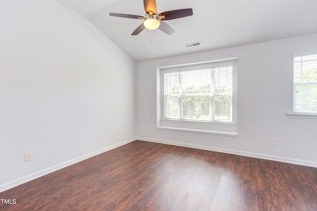 spare room with dark wood-style flooring, baseboards, vaulted ceiling, and ceiling fan