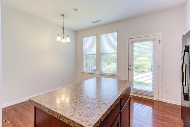 kitchen with decorative light fixtures, visible vents, light countertops, dark wood-style floors, and a chandelier