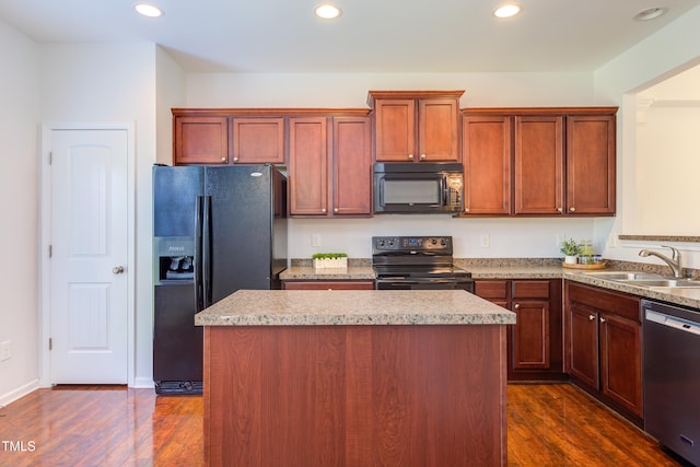 kitchen featuring a sink, recessed lighting, dark wood-type flooring, a kitchen island, and black appliances