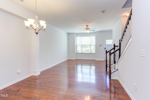 unfurnished living room featuring stairs, dark wood-style flooring, and baseboards