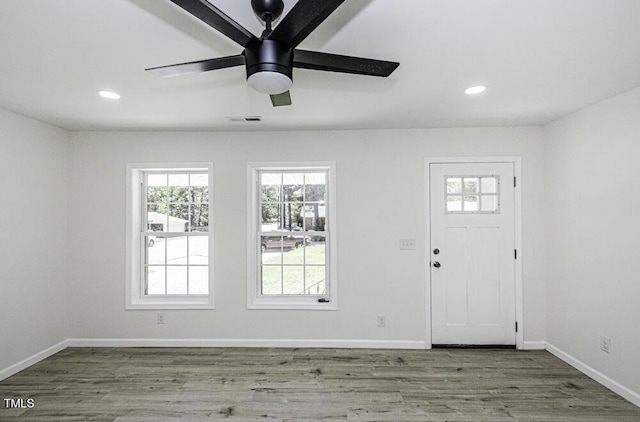 foyer featuring wood finished floors, visible vents, a healthy amount of sunlight, and a ceiling fan