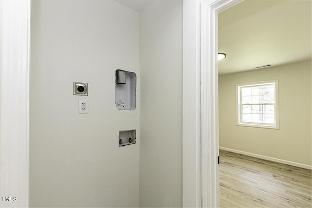 clothes washing area with washer hookup, electric dryer hookup, baseboards, wood finished floors, and laundry area