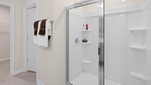 320 Hanging Elm Ln, Fuquay Varina, NC 27526 - bathroom featuring baseboards, a spacious closet, and a stall shower