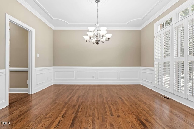 unfurnished dining area featuring a chandelier, visible vents, wood finished floors, and wainscoting