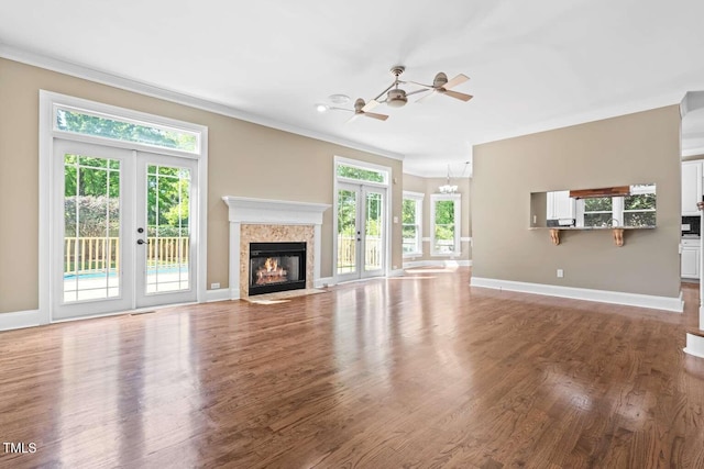 unfurnished living room featuring baseboards, ceiling fan, french doors, and crown molding