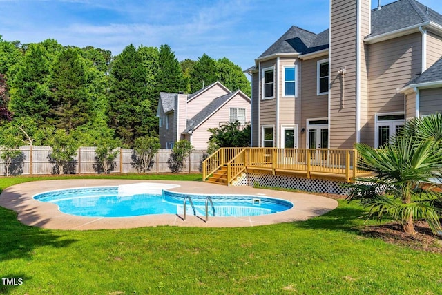 view of swimming pool featuring a deck, fence, a fenced in pool, and a yard