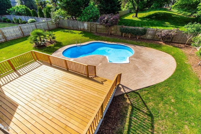 view of swimming pool featuring a deck, a yard, a patio, and a fenced backyard