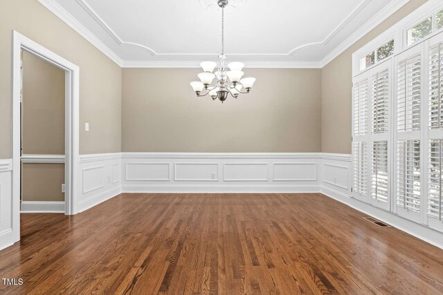 102 Traviliah Oaks Ln, Cary, NC 27518 - unfurnished dining area featuring a chandelier, wood finished floors, a wainscoted wall, and crown molding