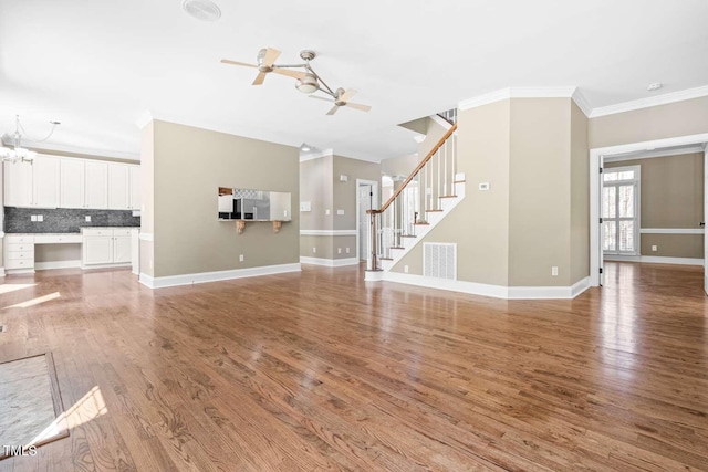 102 Traviliah Oaks Ln, Cary, NC 27518 - unfurnished living room with crown molding, light wood-type flooring, stairs, ceiling fan, and baseboards