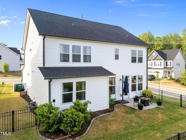rear view of house with cooling unit, a patio, a fenced backyard, a shingled roof, and a yard