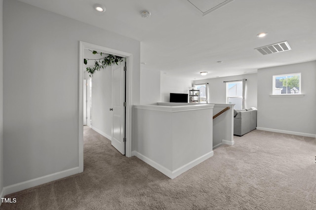 kitchen featuring light colored carpet, recessed lighting, baseboards, open floor plan, and visible vents