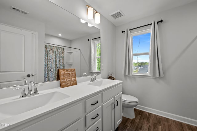 full bathroom with toilet, visible vents, and a sink