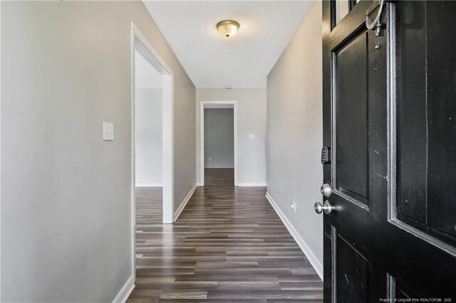 foyer entrance with wood finished floors and baseboards