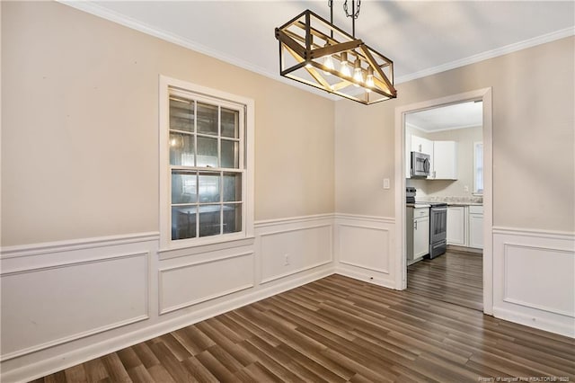 unfurnished dining area with wainscoting, a decorative wall, crown molding, and dark wood-type flooring