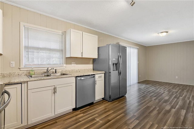 kitchen featuring white cabinets, dark wood-style floors, a sink, appliances with stainless steel finishes, and ornamental molding