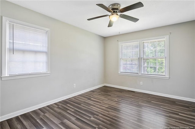 empty room with a ceiling fan, baseboards, dark wood-style flooring, and visible vents