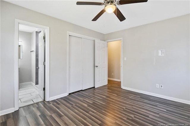 unfurnished bedroom with dark wood finished floors, a ceiling fan, ensuite bath, a closet, and baseboards
