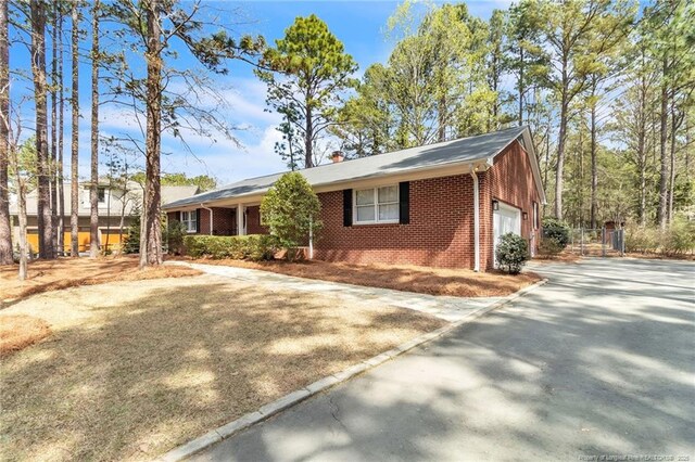 83 Pine Lake Dr, Whispering Pines, NC 28327 - single story home with brick siding, driveway, and a garage