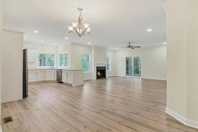 45 Martin Dr, Whispering Pines, NC 28327 - unfurnished living room featuring healthy amount of natural light, light wood-style flooring, recessed lighting, a warm lit fireplace, and a chandelier