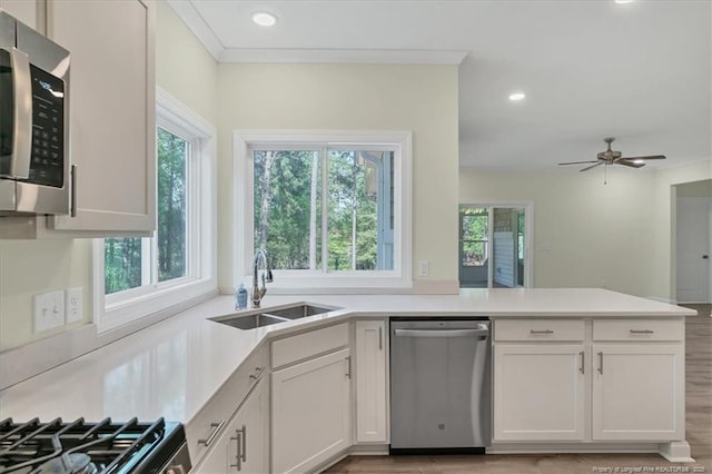 45 Martin Dr, Whispering Pines, NC 28327 - kitchen with stainless steel appliances, plenty of natural light, a peninsula, white cabinetry, and recessed lighting