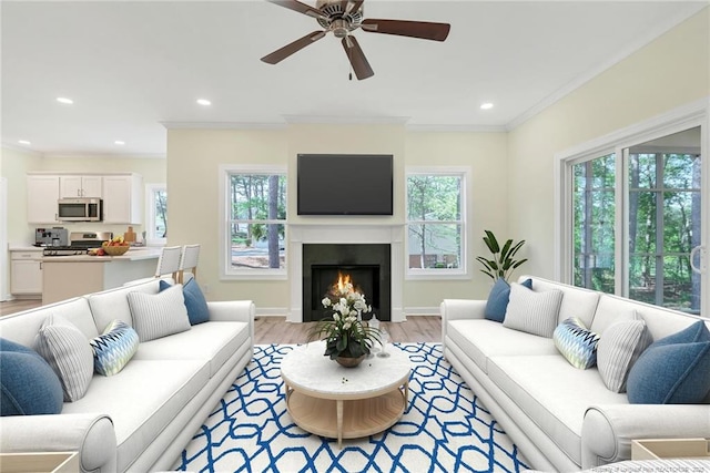 45 Martin Dr, Whispering Pines, NC 28327 - living area featuring light wood-style floors, ceiling fan, crown molding, a lit fireplace, and recessed lighting
