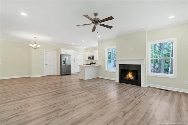 45 Martin Dr, Whispering Pines, NC 28327 - unfurnished living room with light wood-style flooring, ornamental molding, a chandelier, a warm lit fireplace, and a ceiling fan