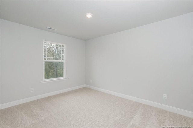 unfurnished room with visible vents, recessed lighting, baseboards, and light colored carpet
