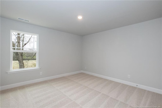 spare room with light colored carpet, baseboards, visible vents, and recessed lighting