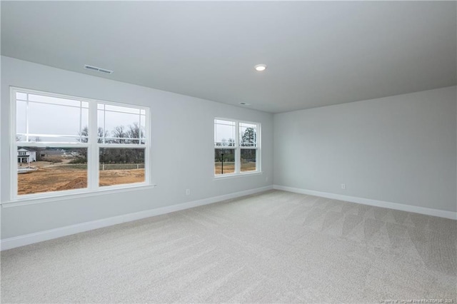 spare room with baseboards, light carpet, recessed lighting, and visible vents