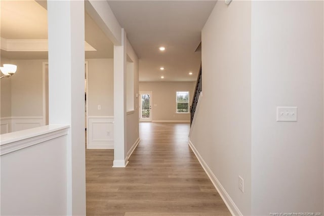 hallway featuring wainscoting, recessed lighting, and light wood-style flooring