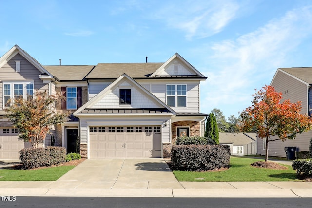 view of front of property with a front lawn, driveway, and stone siding