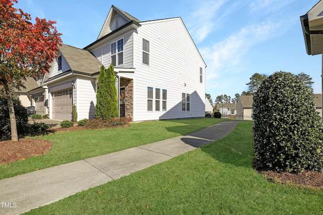 view of side of home with stone siding, an attached garage, and a yard