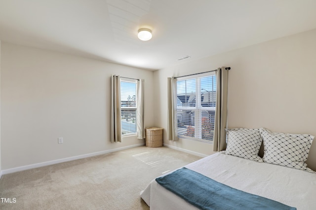 carpeted bedroom with baseboards and visible vents