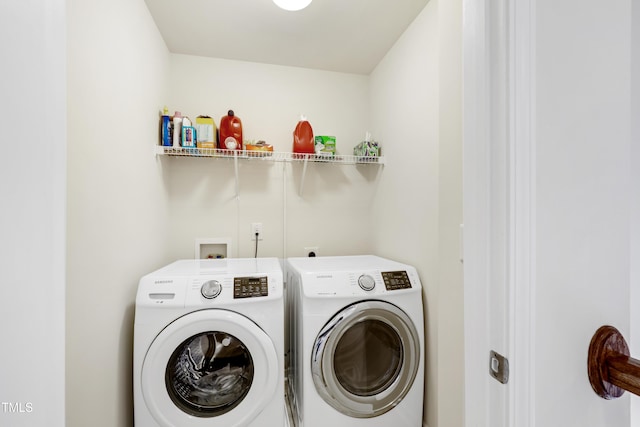 clothes washing area with washer and clothes dryer and laundry area