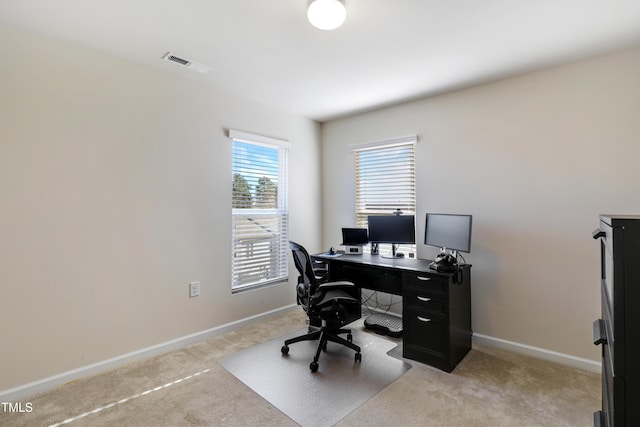 home office with baseboards, light carpet, and visible vents