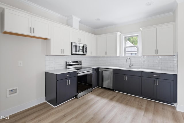 1448A Maplewood Dr, Durham, NC 27704 - kitchen with stainless steel appliances, a sink, white cabinetry, light wood finished floors, and ornamental molding