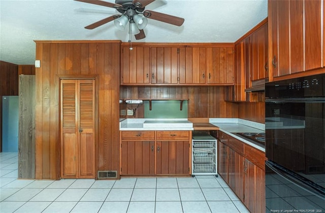 kitchen with brown cabinets, under cabinet range hood, and ceiling fan