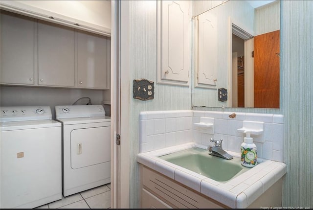 bathroom with tile patterned flooring, wallpapered walls, vanity, and washer and dryer